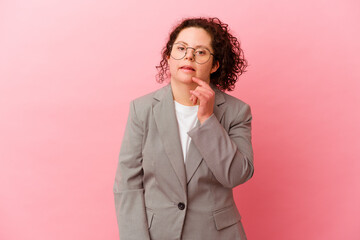 Business woman with Down syndrome isolated on pink background biting fingernails, nervous and very anxious.