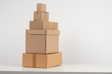 Cardboard boxes of different sizes on a white background. Packaging materials concept next to the place for the text. Eco-friendly packaging. Biodegradable boxes. Caring for the environment.