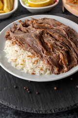 Meat on rice turns over on a dark ground. Turkish kebab doner