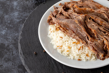 Meat on rice turns over on a dark ground. Turkish kebab doner