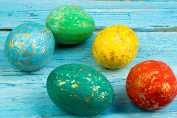 Happy Easter card. Colorful shiny easter eggs on wooden background. Copy space for text.