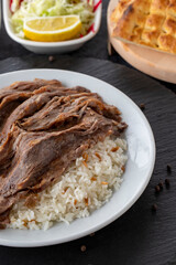 Meat on rice turns over on a dark ground. Turkish kebab doner