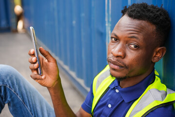 African American black men playing, online chatting or browsing on mobile phone while taking a...