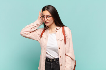 young pretty woman looking serious and curious, listening, trying to hear a secret conversation or...