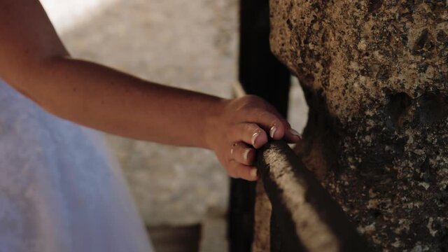 Bridal walking downstairs on holding handrail with hand and wedding ring. Close up shot.