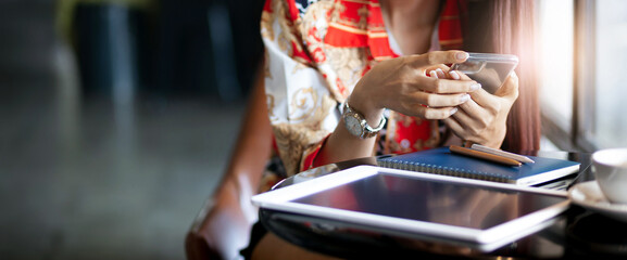 Close up, young female touching smart phone to use mobile app after work in cafe