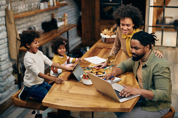 African American family using wireless technology at home.