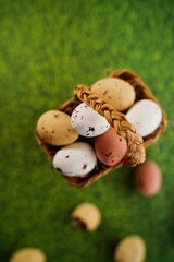 Easter freckled chocolate eggs on green grass background, selective focus