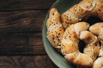 Freshly baked homemade croissants on wooden table. Selective focus. Fresh out of the oven. Breakfast or brunch concept.