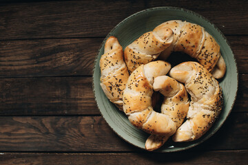Freshly baked homemade croissants on wooden table. Selective focus. Fresh out of the oven. Breakfast or brunch concept.