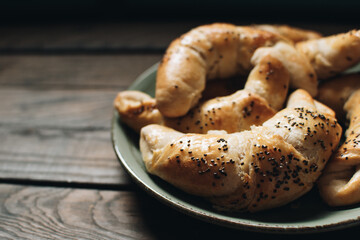 Freshly baked homemade croissants on wooden table. Selective focus. Fresh out of the oven. Breakfast or brunch concept.