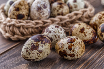 Group of quail eggs are put on clear tray on wooden table.