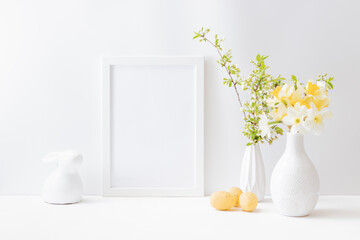 Home interior with easter decor. Mockup with a white frame and spring flowers in a vase on a light background