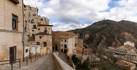 view of the old city center in Cuenca with a narrow street leading down to the Casas Colgadas or "hanging houses"