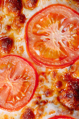 pizza Margarita close up with cheese and tomatoes.