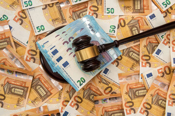 50 euro banknotes with wooden hammer as bribe concept