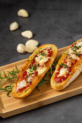 Bruschetta with cherry tomatoes, mozzarella and basil on wooden board. Caprese salad.