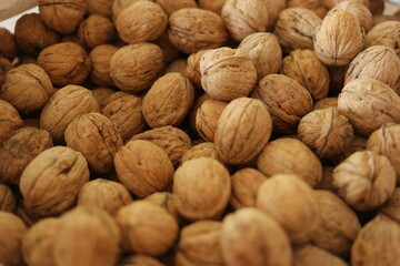 Pile of walnuts at the farmers market. Close up of walnuts background. Healthy organic food concept.
