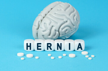Cubes lie on the table among the pills and imitation of the brain. The text on the dice - HERNIA