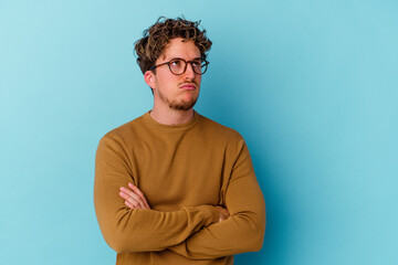 Fototapeta premium Young caucasian man wearing eyeglasses isolated on blue background tired of a repetitive task.