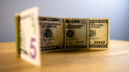 10 20 100 dollars are on the table, side view, the watermark on the banknote is seen through