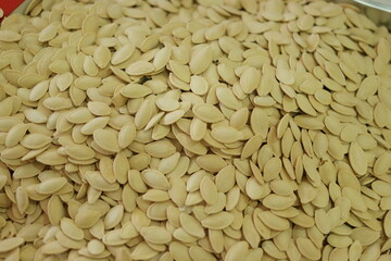 Heap of white roasted pumpkin seeds. Raw pumpkin seeds background.