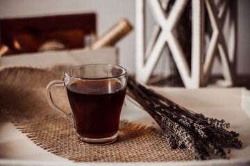 Cup of tea on a white tray, dried flowers, dark background, lavender