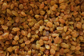 Dried golden raisins background. Pile of dried yellow raisins.