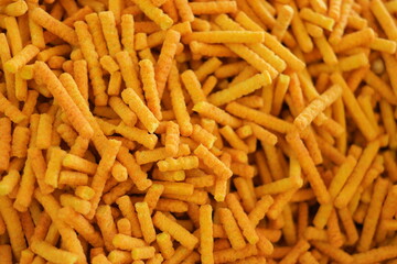 Crispy corn snack close up. Cheese flavoured snack background. Fast food concept.