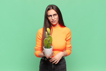 young pretty woman feeling puzzled and confused, with a dumb, stunned expression looking at...