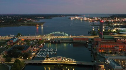 Aerial shot of vehicles on bridge over river at dusk, drone flying forward over city - Providence, Rhode Island