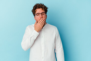 Young caucasian business man isolated on blue background yawning showing a tired gesture covering mouth with hand.