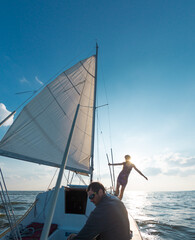 A man and a woman are traveling on a sailing yacht.