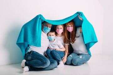 Obraz na płótnie Canvas young family in medical masks during home quarantine.