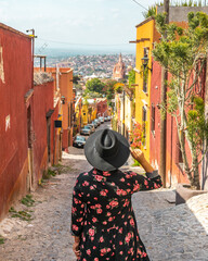 Woman in front of colorful street in the colonial city of San Miguel de Allende, Mexico