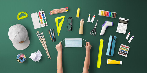 Flat lay top view of face mask and school supplies, back to school and coronavirus concept.