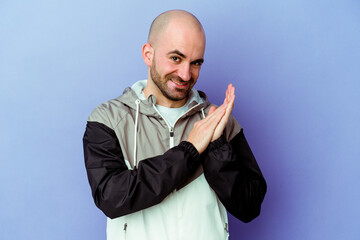Young caucasian bald man isolated on purple background feeling energetic and comfortable, rubbing hands confident.