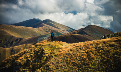 Hiker walking on mountain ridge in colorful autumn in Carpathian Tatra mountains