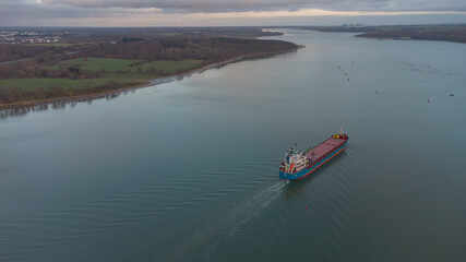 A cargo ship sailing down the River Orwell in Suffolk, UK