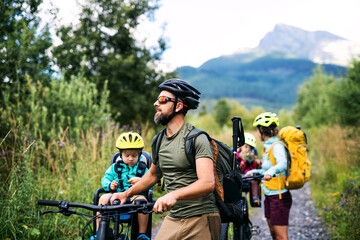 Family with small children with bicycles outdoors in summer nature, High Tatras in Slovakia.