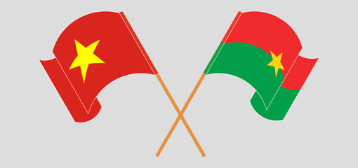 Crossed and waving flags of Vietnam and Burkina Faso