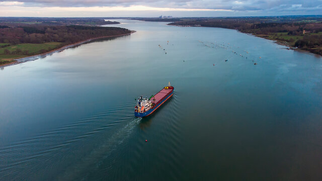 A cargo ship sailing down the River Orwell in Suffolk, UK