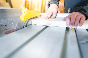 Brett wird vom Schreiner an der Säge bearbeitet