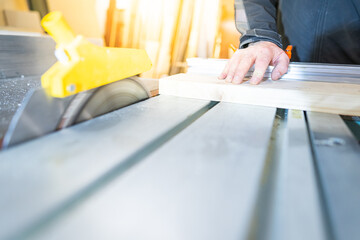 Brett wird vom Schreiner an der Säge bearbeitet