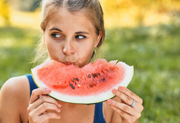 Young stylish lady in the park with a watermelon
