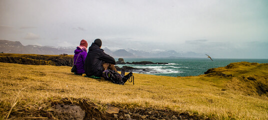 Couple looking at sea in windy weather in Iceland