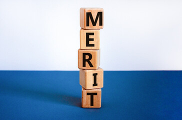 Merit symbol. Wooden cubes with the word 'merit'. Beautiful white and blue background, copy space....