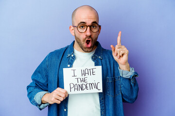 Young caucasian bald man holding a I hate the pandemic placard isolated on blue background having...