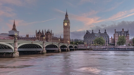 Fototapeta na wymiar Houses of Parliament with Big Ben and double-decker buses on Westminster bridge at sunset, London, United Kingdom