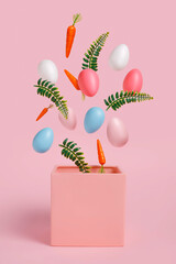 Easter eggs, leaves and carrots coming out of pink box on pastel pink background. Minimal spring nature concept. Easter holiday background idea.